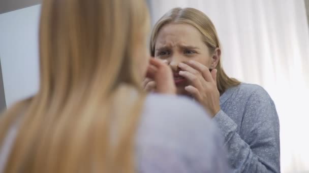 Naštvaná teenagera, kontrola stavu pokožky obličeje, kožní problémy, péče o tělo — Stock video