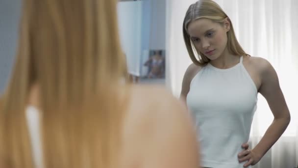 Dívka pózuje v nové bílé tričko u zrcadla, dospívající rozvoj, budoucí model — Stock video