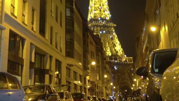 Lättade Eiffeltornet i natt Paris berömda landmärke utsikt från gatan — Stockvideo