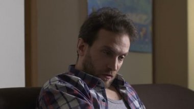 Yetişkin alkollü kanepede oturan ve şişe bira, yıkımı için konuşuyor