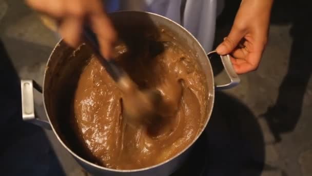 Femme en remuant savoureux caramel dans une grande casserole, pâtisserie maison, dessert 