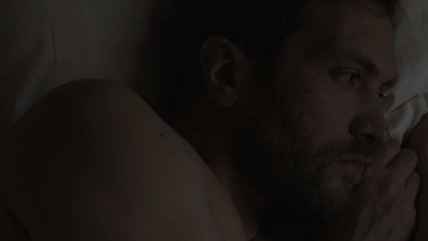 Uykusuzluk, uyku bozukluğu, sorunları acı yatakta yatan endişe yakışıklı adam — Stok video