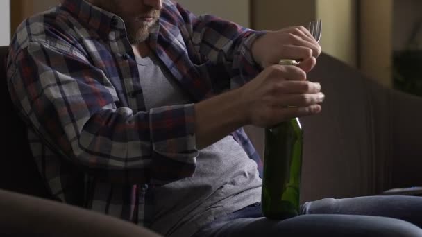 Alcoholische bierfles openen met vork op home Bank, ongezonde gewoonte verslaving — Stockvideo