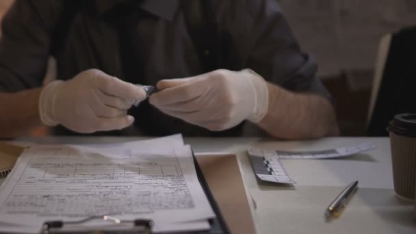 Детектив, що проводить експертизу доказів, вимірює і пише кулі калібру — стокове відео