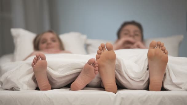 Menina flertando com namorado na cama tocando os pés, jogando dedos dos pés, relacionamento — Vídeo de Stock