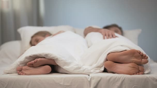 Young man and woman sleeping back to back, scratching feet, fungal disease — Stock Video