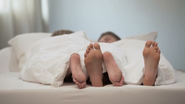 Lyckligt par fötter i smekmånad säng, härlig konversation i morgon, äktenskap — Stockvideo