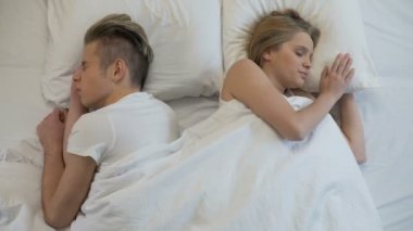 Mutlu bir adam ve kadın yatakta sabah uyanma, gülümseyerek ve tutan eller