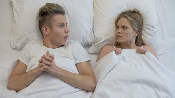 Junges Paar, das vor dem ersten Erlebnis im Bett schockiert wirkt, mangelnde Sexualerziehung — Stockvideo
