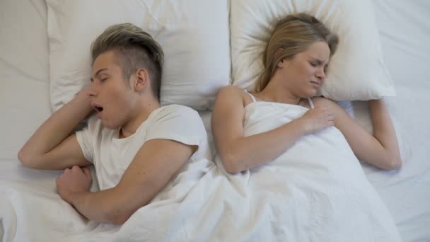 Annoyed woman closing ears while man snoring loudly in bed, apnea disease — Stock Video