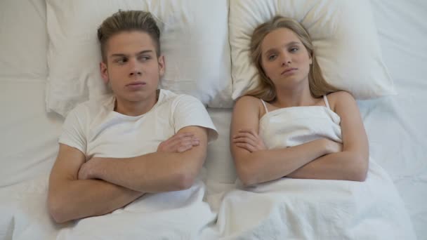 Расстроенная молодая пара, лежащая в постели, сексуальные проблемы, непонимание отношений — стоковое видео