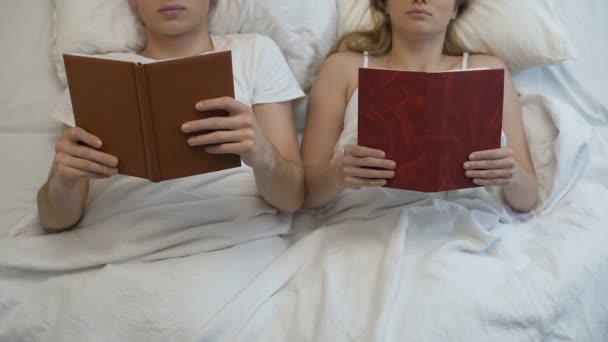 Jovem casal lendo livros na cama ignorando uns aos outros, problema íntimo, descanso — Vídeo de Stock