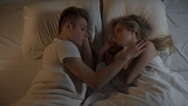 Az ember finoman simogató womans haj és a test, szerető pár pihentető az ágyban éjjel — Stock videók