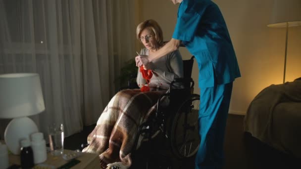 Nurse taking away knitting needles from old woman due to Parkinsons disease — Stock Video