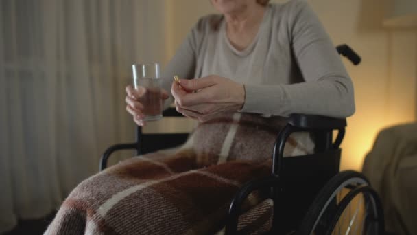Θλιβερή ηλικιωμένη γυναίκα σε αναπηρική καρέκλα, λαμβάνοντας το φάρμακο, περίοδος αποκατάστασης, κατάθλιψη — Αρχείο Βίντεο