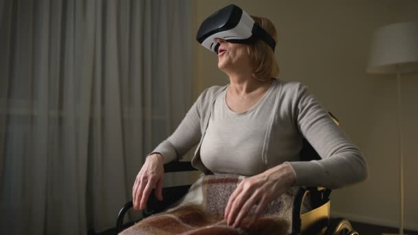 Donna in sedia a rotelle indossando auricolare vr per la prima volta, felice e sorpreso — Video Stock