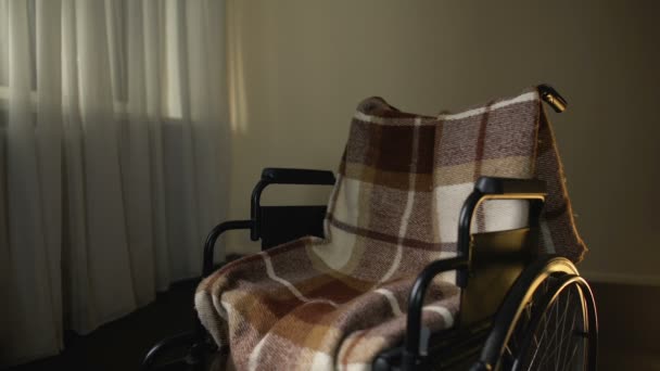 Daughter stroking empty wheelchair with sorrow, remembering mother passed away — Stock Video