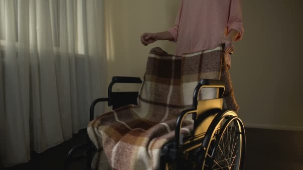 Kobieta, odbierając pusty wózek inwalidzki, myśląc o matce, smutku dla ukochanej — Wideo stockowe