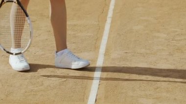 Kadın tenis topu hizmet vermektedir, aktif spor, bacaklar için rahat ayakkabılar yakın çekim