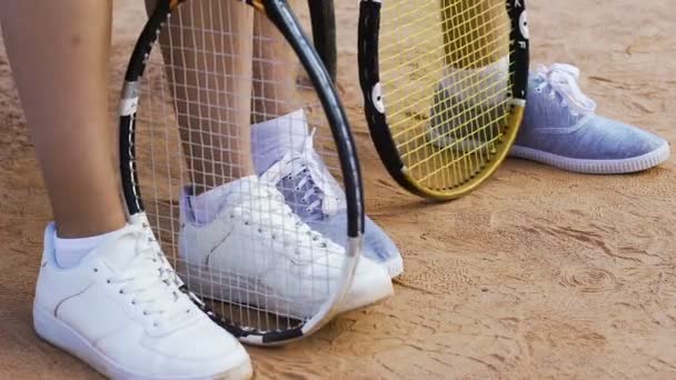 Jugadores de tenis sentados en el banco, esperando el partido, girando nerviosamente raquetas — Vídeos de Stock