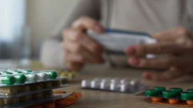 Tablo, kadın okuma talimatları, pahalı ilaç haplarla closeup