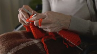 Kadın sallayarak çalışırken örgü, hobi, parkinson hastalığının belirtisi konsantre eller