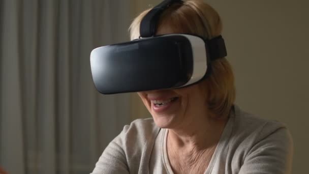 興奮して老年女性の仮想現実の眼鏡、近代的な技術を使用して楽しんでいます — ストック動画