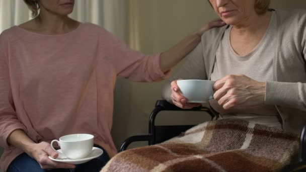 Filha tentando persuadir a mãe a ir para casa de repouso, sentado sobre a xícara de chá — Vídeo de Stock