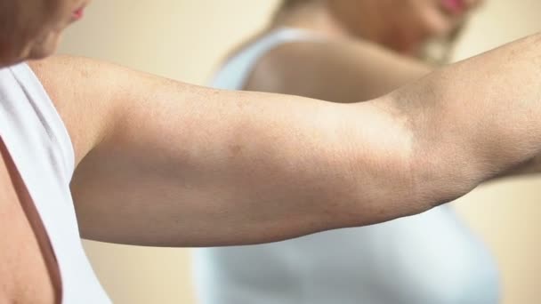 Femme âgée regardant la peau sur les bras, prenant soin d'elle-même, les changements de vieillissement — Video