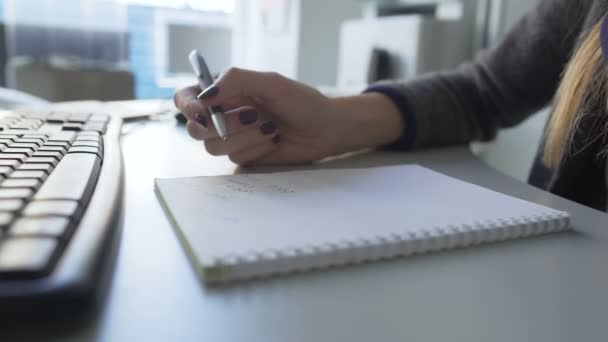 Escritório senhora à procura de algo na internet e tomar notas em seu caderno — Vídeo de Stock