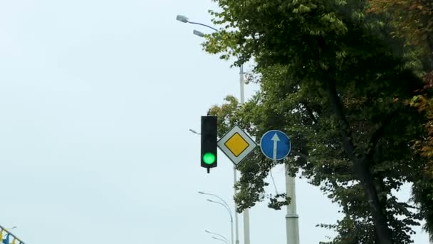 Car driving along city street on green traffic light, road warning sign, control — Stock Video