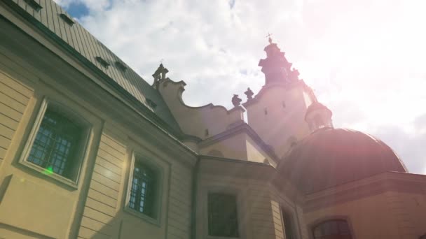 Rayos de sol iluminando hermoso edificio de la iglesia en Lviv, lugar de oración, bendición — Vídeos de Stock