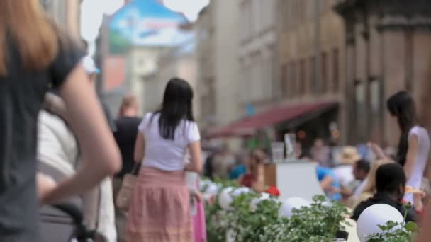 LVIV, UCRÂNIA - CIRCA JULHO 2017: Pessoas na cidade. Pessoas que passam por café de rua, área turística lotada em Lviv cidade velha, recreação — Vídeo de Stock