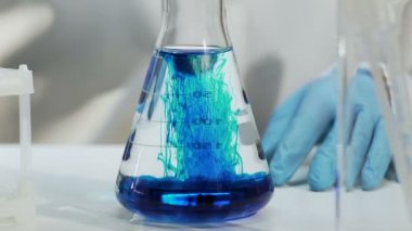 Laboratuar asistanı deneyler ev Kimyasalları üretim yapmaktadır.