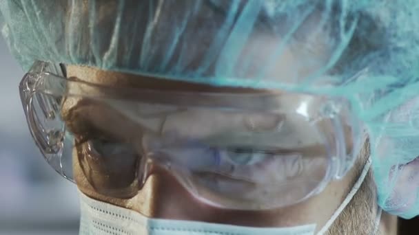 Científico médico en gafas protectoras trabajando en laboratorio, cara de cerca — Vídeos de Stock