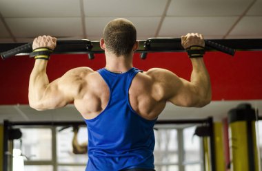 Pull-up spor yaparken ideal kaslı vücut ile profesyonel vücut geliştirmeci