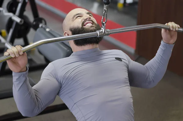 Тренировка мускулистого культуриста в тренажерном зале, упражнения для расслабления мышц — стоковое фото