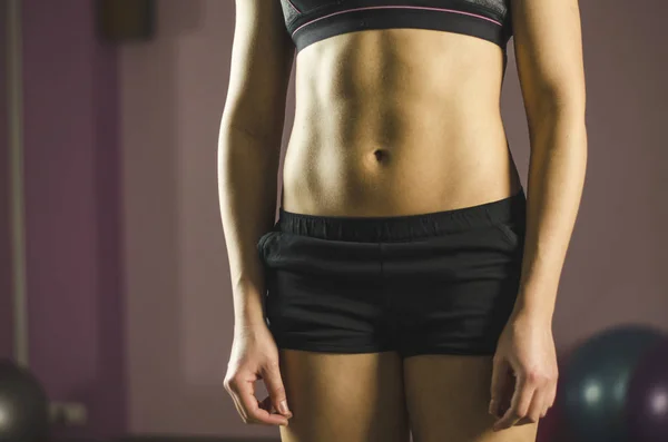 Плоский живот молодой женщины, тренирующейся в фитнес-клубе, красивое здоровое тело — стоковое фото