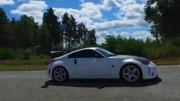 Weißes Auto fährt auf Rennstrecke außerhalb der Stadt, erfahrener Rennfahrer — Stockvideo
