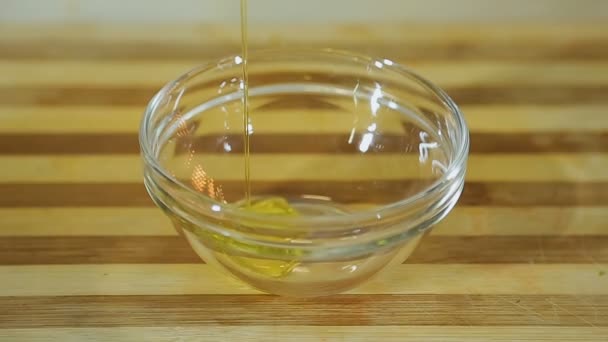 Оливковое масло, вылитое в стеклянную миску, природная косметика, увлажняющий эффект — стоковое видео