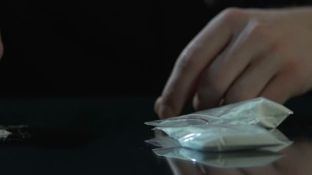 Drugsdealer waardoor cocaïne lijnen door kaart met drug pakketten op tafel, verslaving — Stockvideo