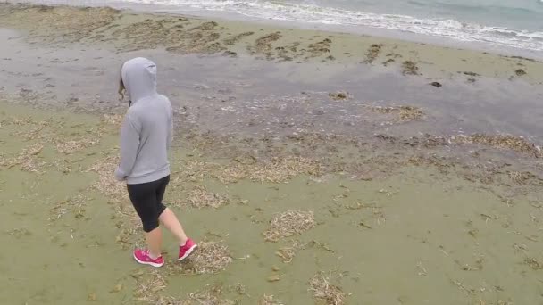 孤独的女人走在空旷的海岸线上, 思考着生活, 忧郁 — 图库视频影像