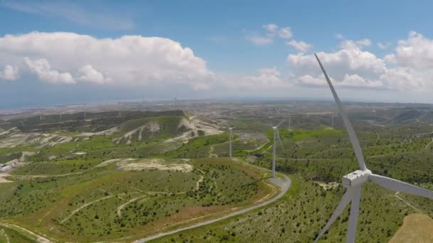 Viadukt över gröna fält med vindkraftverk, alternativ energi, antenn — Stockvideo