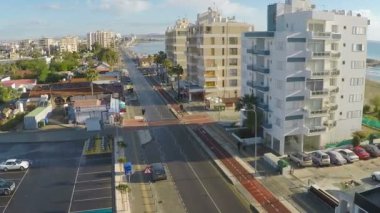 Araba park ve yüksek binalar üzerinde uçan uçak sahil yakınında Larnaka şehir yerleştirilen