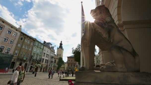 LVIV, UCRANIA - CIRCA JULIO 2017: Personas en la ciudad. Felices turistas mirando el antiguo monumento del león en la Plaza del Mercado en la ciudad de Lviv — Vídeos de Stock