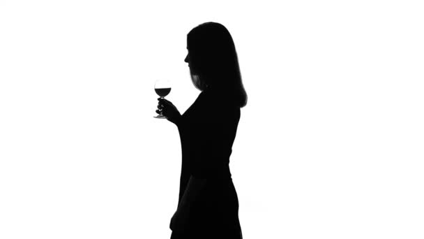 Silhouette einer leicht betrunkenen Frau, die ein Glas Wein trinkt, tanzt und flirtet — Stockvideo