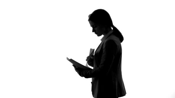 Silhouette of businesswoman talking on phone, arranging meeting, checking agenda — Stock Video