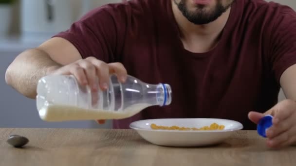 Mužské nalévá mléko a snídá cereálie s radostí, zdravá výživa — Stock video