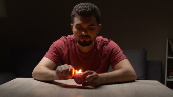 Человек зажигает свечу на столе дома, расслабляет мысли, душевное спокойствие — стоковое видео