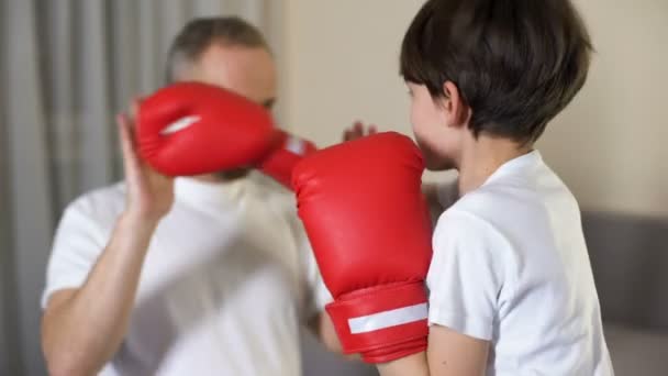 Liten pojke boxning med sin styvfar, lärande attackerande, familj samhörighet — Stockvideo